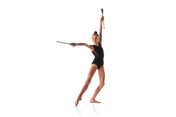 Emotions in motion. Portrait of junior gymnast in black sport swimsuit doing gymnastics excercises isolated over white background. Sport, skills, achievements