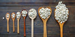 Haricot beans in wooden spoons on rustic table, geometric progression concept. Flat lay