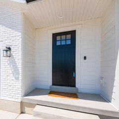 Wall Mural - Square Facade of a house with white exterior and black front door with glass, doorbell camera and lockbox