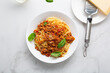 Top view of italian pasta spaghetti bolognese in bowl on light surface