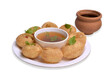 Delicious north and south indian street food pani puri gol gappa with tamarind water served in white plate and mud pot with potato and chickpeas with transparent background