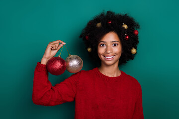 Sticker - Photo portrait of nice pupil girl holding new year tree decoration balls wear trendy red knitted clothes isolated on green color background