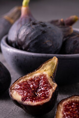 Wall Mural - Some ripe figs in a bowl on a gray background. in the foreground part of a succulent fig