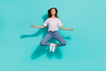 Wall Mural - Full size photo of calm relaxed woman with brown hair wear striped t-shirt levitating in yoga pose isolated on teal color background