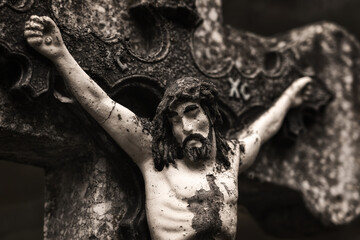 Wall Mural - Ancient stone sculpture of Jesus Christ, crucified on a stone cross