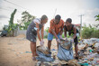 © Media Lens King - Three young people pick up trash that pollutes the environment. Clean world concept