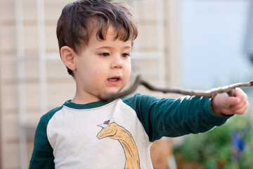 expressive little boy playing in the backyard and making faces