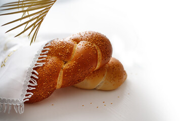 Challah bread covered with a special napkin on white background. Traditional Jewish Shabbat ritual. Shabbat Shalom.