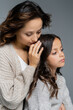 © LIGHTFIELD STUDIOS - young woman in knitwear hugging head of brunette daughter isolated on grey