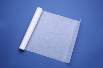 Canvas Print - Roll of baking paper on blue background, top view