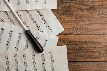 Poster - Conductor's baton and sheet music on wooden table, flat lay. Space for text