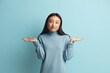 Confused Woman Shrugging Hands. Portrait of Uncertain Asian Girl Expressing Doubts and Bewilderment, Looking at Camera with Question So What, Who Cares. Indoor Studio Shot Blue Background 