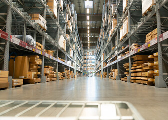 View from the transport trolley to a large warehouse in the aisle between the shelves and racks