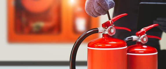 Wall Mural - Fire extinguisher has hand engineer inspection checking pressure gauges to prepare fire equipment for protection and prevent in emergency case and safety or rescue and alarm system training concept.