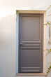 © OceanProd - Wooden Door grey modern on french wall city street classic facade
