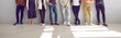 © Studio Romantic - Banner with diverse fashion models posing in studio. Group of multiethnic business people in smart casual outfits standing on floor by office wall. Cropped low section shot of men's and women's legs