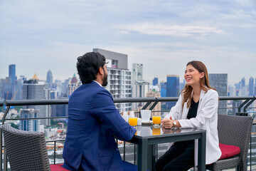 Happy lunch with couple of businessman and woman on rooftop restaurant and good cityscape view