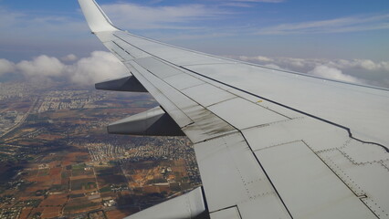 Wing of an airplane flying over Israel, Passenger s view. Looking through the window of a plane on its shining wing