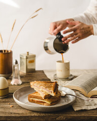 breakfast with sandwiches, egg and coffee at wooden table