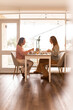 © Austockphoto - Female same sex couple eating a meal together at home