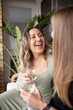 © Austockphoto - close up shot of smiling same sex couple sitting outside, talking and drinking wine