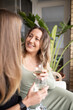 © Austockphoto - close up shot of smiling same sex couple sitting outside, talking and drinking wine