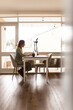 © Austockphoto - Woman working from home at kitchen table on laptop