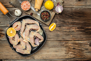 Wall Mural - raw fillet steak of sturgeon fish on a grill pan on a wooden background,