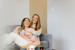 © Austockphoto - Lesbian couple laughing and hugging on the couch