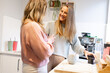 © Austockphoto - Two smiling blonde women talking as they make coffee in their  kitchen