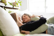 © Austockphoto - Female same sex couple  affectionately lying together on the bed, smiling at one another