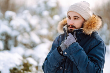 Wall Mural - Bearded man smiling at camera in winter park. Season, christmas, travel and people concept.