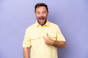 Wall Mural - Middle age caucasian man isolated on purple background with surprise facial expression