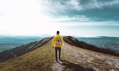 Canvas Print - Young man with backpack hiking mountains - Hiker having trekking day out on a sunny day - Successful, sport and inspirational concept