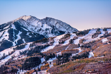 Aerial high angle view of ski resort town city of Aspen, Colorado after winter snow on Buttermilk mountain slopes with valley in autumn fall