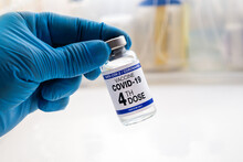 COVID-19 Vaccine Vial For Vaccination Tagged With 4th Dose. Doctor With Coronavirus Vaccine Bottle With The Name Of The Fourth Vaccine On The Label