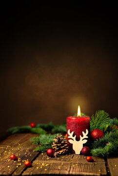 Fototapete - Kerze zum 1. Advent und Weihnachten. Dekoration mit roter Adventskerze, Tannenzweigen, Zapfen, Kugeln und Rentier auf Holz. Hochformat mit Textraum