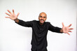 © KAMPUS - Portrait of happy young man holding out arms. Excited African American male model with bald head and beard in black shirt looking at camera, ready to catch or hug someone. Welcome concept