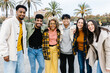 © Xavier Lorenzo - Group portrait of multi-ethnic millennial best friends smiling at camera in Barcelona - United happy young people hugging each other outdoors