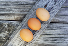 Three Brown Eggs On Wooden Table
