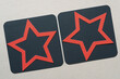 red stars on grungy black squares and blank beige paper