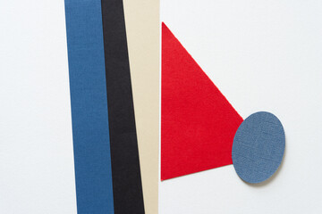 Poster - paper stripes and red triangle covered with a blue oval