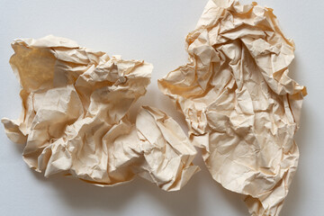 two torn and crumpled paper envelopes on blank paper