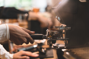 coffee beans ground and coffee powder pouring into holder with coffee machine at a cafe into coffee cup. Coffee machine and coffee bean in a cafe and restaurant counter.