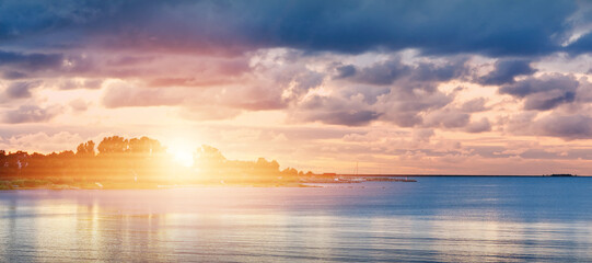 Wall Mural - Soft sunset over ocean. sunset in cloudy day over baltic sea. Beautiful sunset