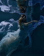 © Pavel Karchevskii - fashionable girl in a beautiful white dress under water in blue light and fluttering fabric in the depths