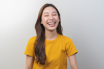 Smiling positive, pretty asian young woman laugh, girl wearing yellow casual, portrait of beautiful brunette her with long hair, feeling happy looking at camera standing isolated on white background.