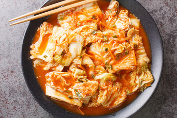 Wall Mural - Close up Korean food, Kimchi cabbage in a black dish on a table. Horizontal top view from above