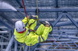 Rope access technicians clean the structure with a high-pressure cleaner