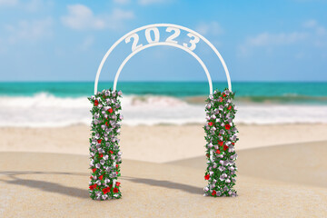 Poster - Welcome to 2023 New Year Concept. Beautiful Decor Arc, Gate or Portal with Flowers and 2023 Sign on an Ocean Deserted Coast. 3d Rendering